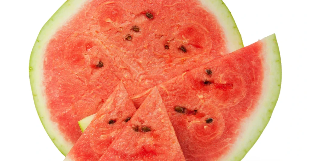 Seeded watermelon cut in half showing red flesh and black seeds