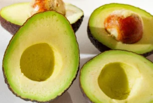 Halved ripe avocados with the seed pit still inside one half